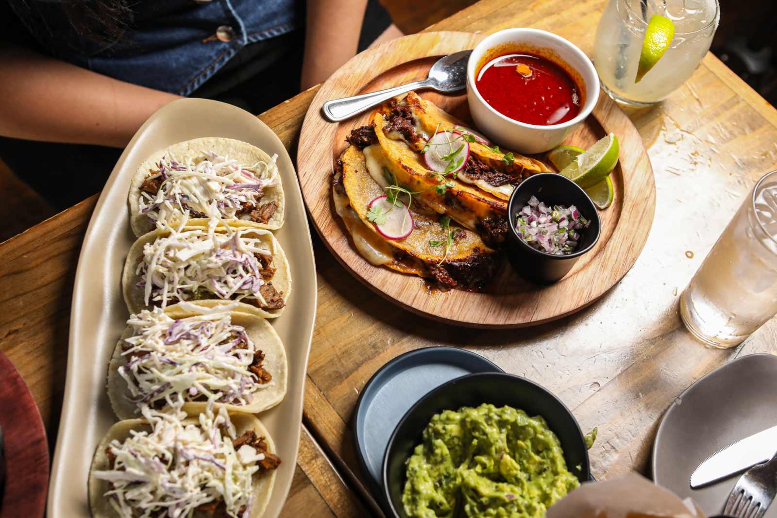 Mercadito brunch table with tacos, guacamole, quesabirria, and margaritas